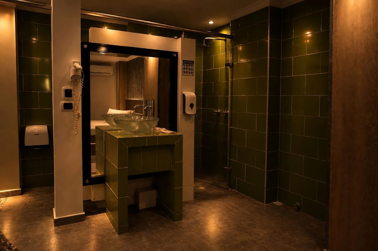 Baño con lavamanos de vidrio y ducha